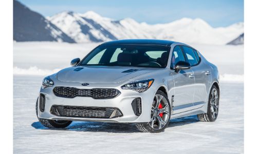 2020 Kia Stinger exterior shot with silver white paint color parked on an icy tundra plain