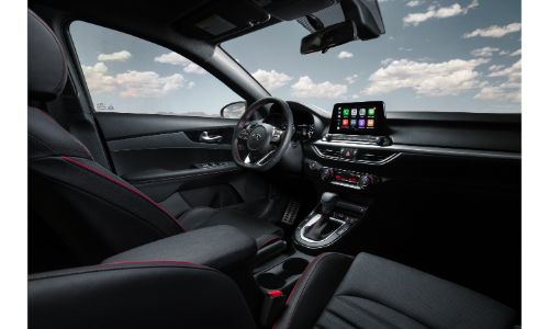 2020 Kia Forte interior shot of front seating upholstery with red stitching, steering wheel, and dashboard layout