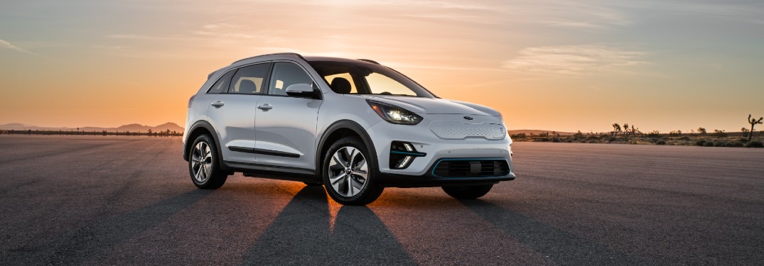 2020 Kia Niro Plug-In Hybrid exterior shot parked on an empty asphalt plain as the sun sets behind it