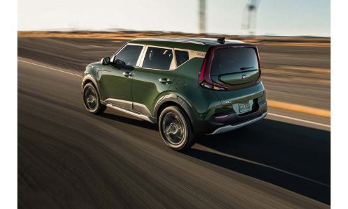 2020 Kia Soul X-Line exterior rear side shot with Undercover Green paint color driving on a desert highway