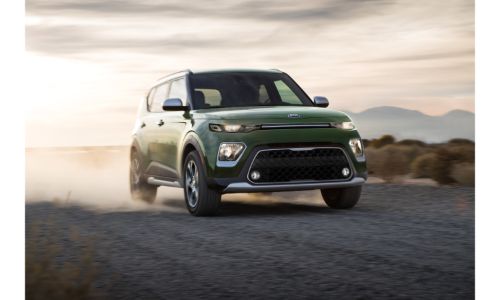 2020 Kia Soul X-Line exterior shot with Undercover Green paint color driving on a dirt road as dust and dirt are kicked up