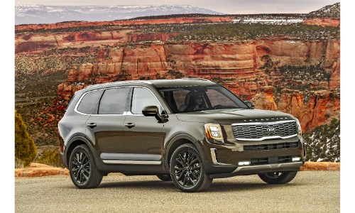 2020 Kia Telluride exterior shot with dark moss green paint color parked on gravel near orange cliffs