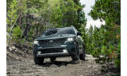 2021 Kia Sorento exterior front shot of grille and headlights driving on a forest trail