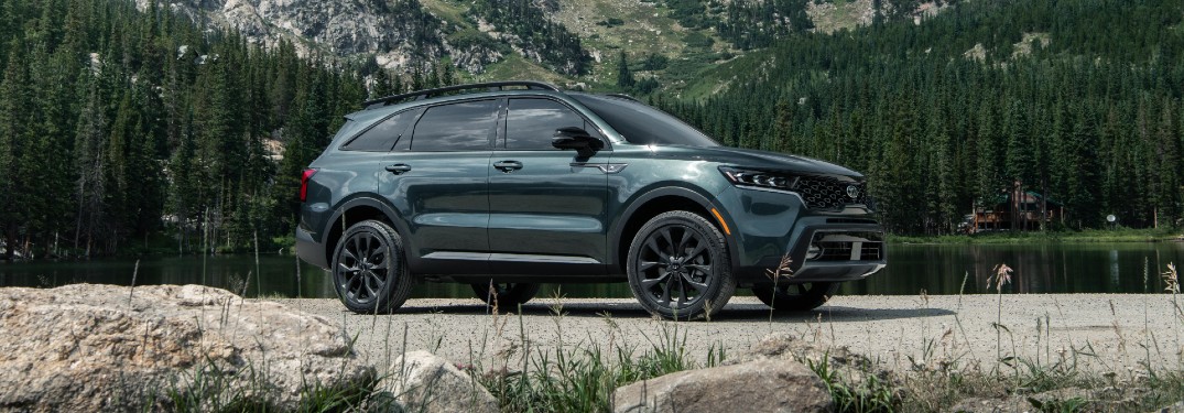 2021 Kia Sorento exterior side shot parked on a gravel field with a background of forest trees and mountains