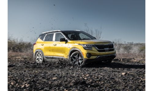2021 Kia Seltos exterior shot with yellow paint color parked on an empty path of dirt and rocks