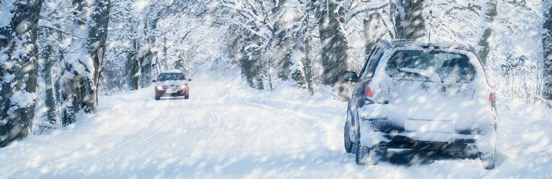 vehicle driving down a winter road covered in snow