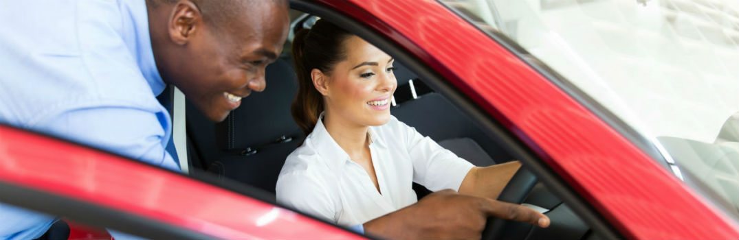 salesman and woman looking at a car