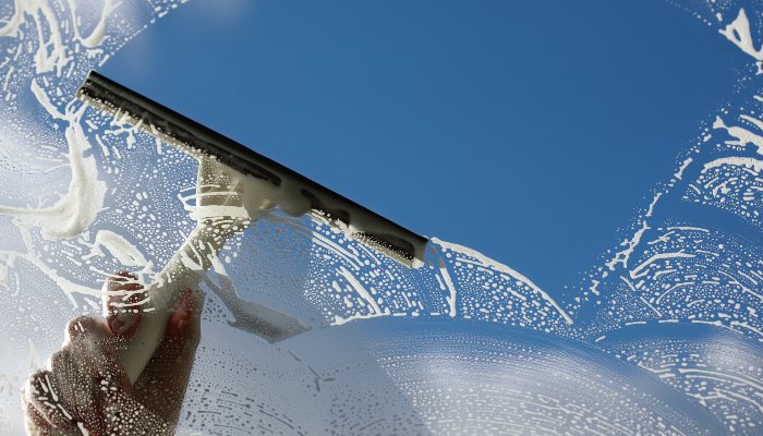 A windshield being cleaned with a squeegee