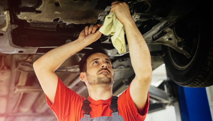 A man working on the underside of a vehicle