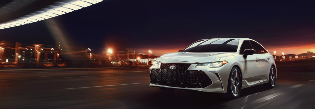 2019 Toyota Avalon Hybrid driving through a city at night