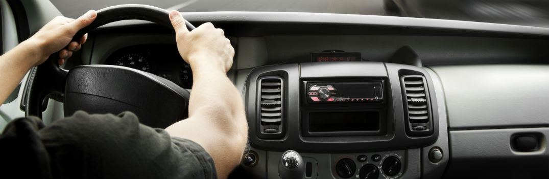 man driving with both hands on steering wheel