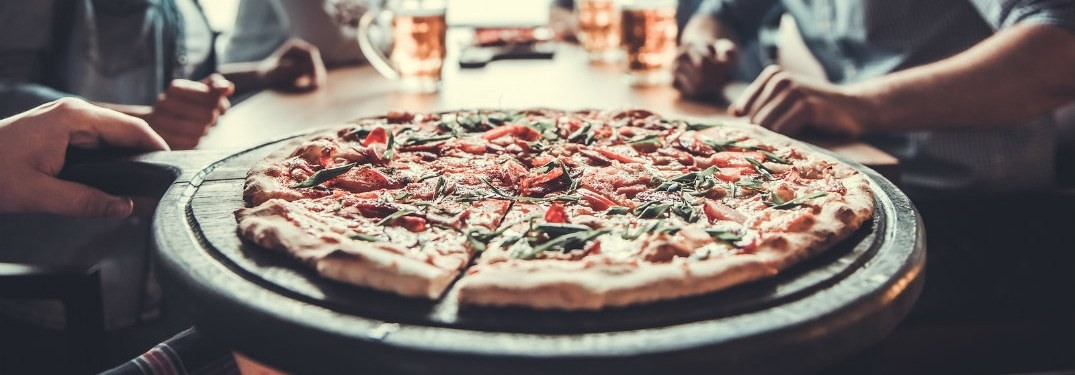 A pizza being served to a group of people