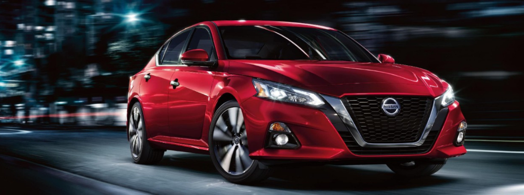 2020 Nissan Altima driving down a city street at night