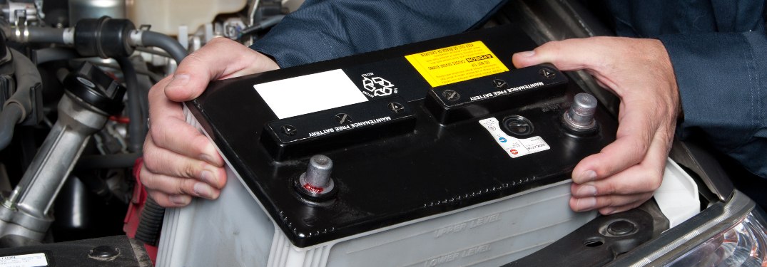 A car mechanic replacing a battery