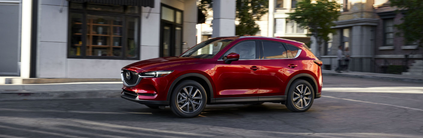 Red Mazda CX-5 driving on the streets during the day