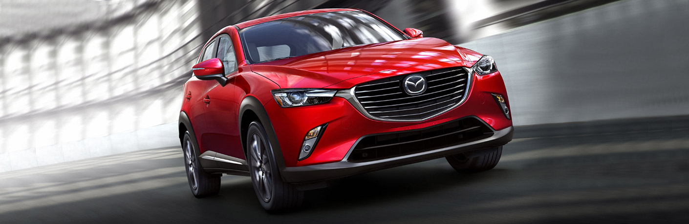 Red Mazda CX3 driving through a lighted tunnel