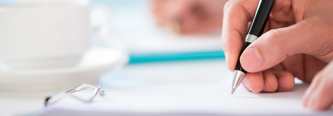person signing contract with pen