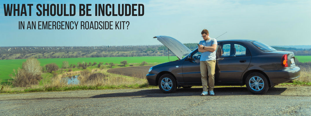 What Should Be Included in an Emergency Roadside Kit? Man Checks Phone While Waiting for Roadside Assistance