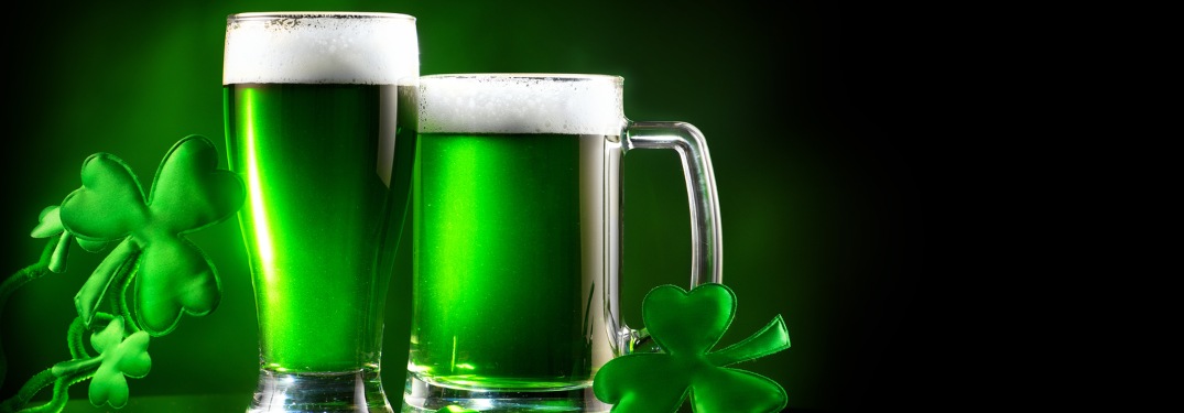 Green beer pints over a black background