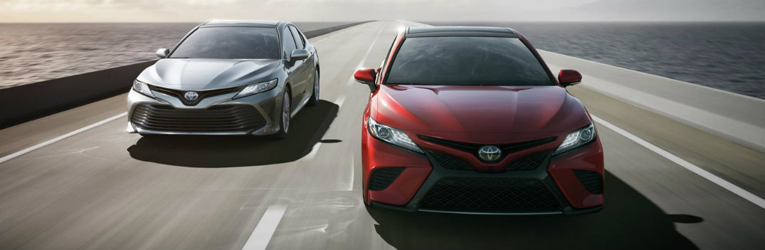 2018 Toyota Camry models driving down a highway over the sea