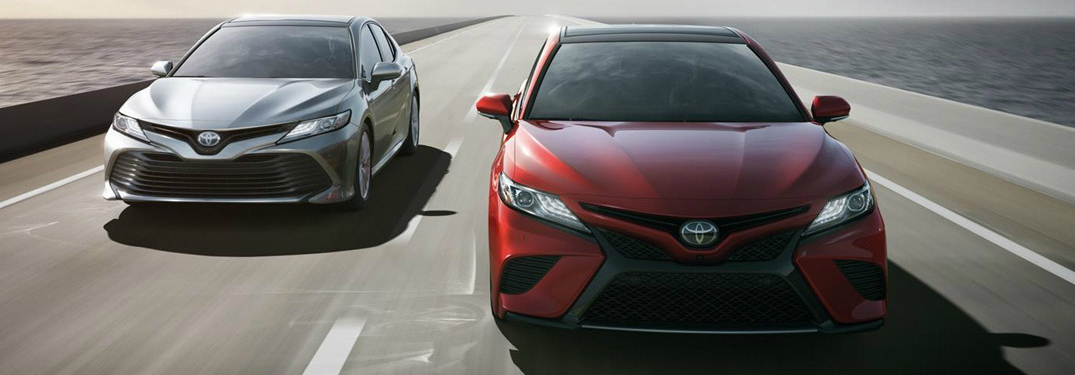 red and silver 2018 toyota camry models driving next to each other on highway bridge