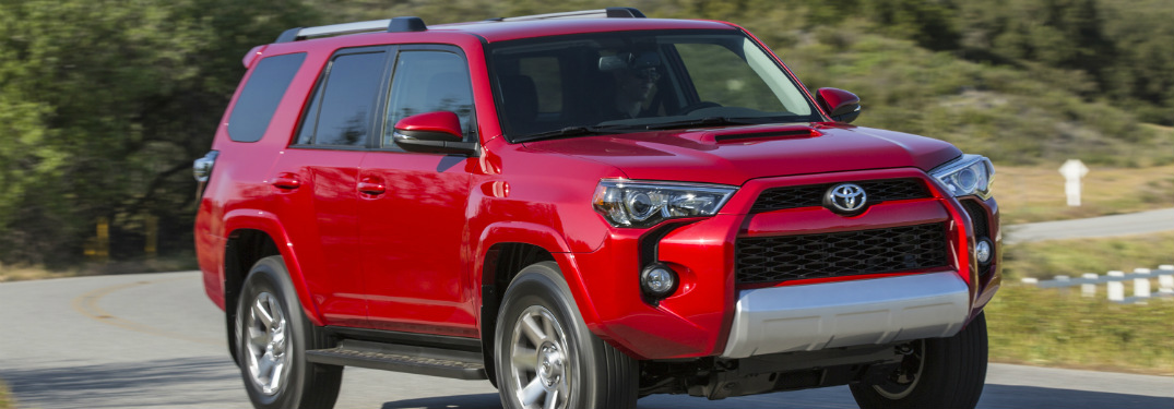 red 2018 toyota 4runner driving on country road