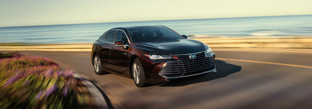 amber 2019 toyota avalon hybrid driving on road next to beach