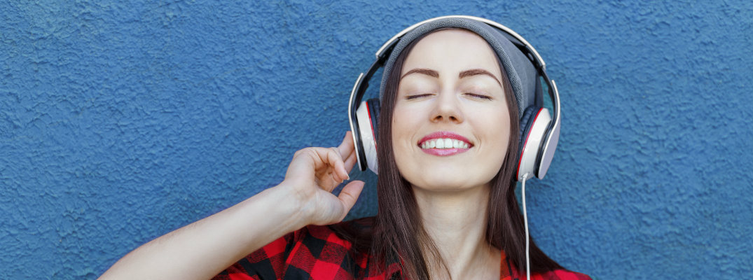 girl in a red plaid shirt listening to music on her headphones