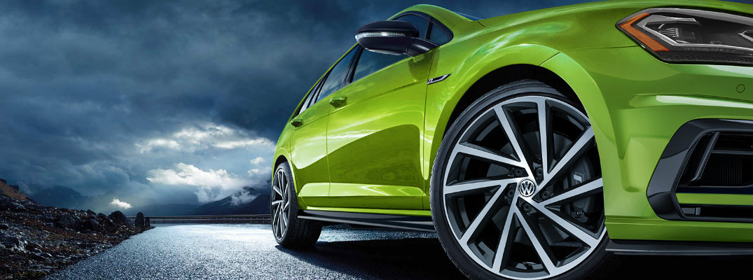 2019 Volkswagen Golf R exterior shot with viper green color paint job low angle shot of turning wheel and a dark cloudy sky