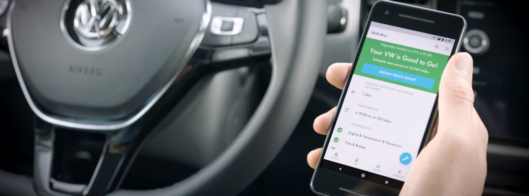 Person Using the VW Car-Net Vehicle Health Report App in a 2018 VW Atlas