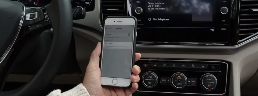 A woman pairing a smartphone with the Bluetooth wireless system in a Volkswagen vehicle