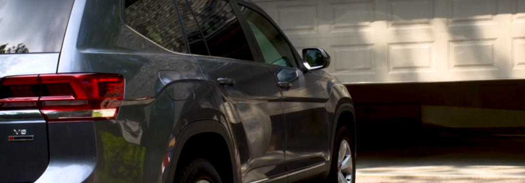 A garage door opening in front of a grey Volkswagen Atlas