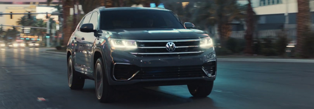 Grey 2020 Volkswagen Atlas Cross Sport driving on a street with palm trees