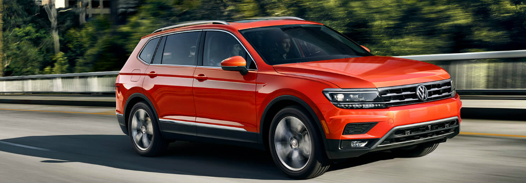 Orange 2019 Volkswagen Tiguan driving over a bridge