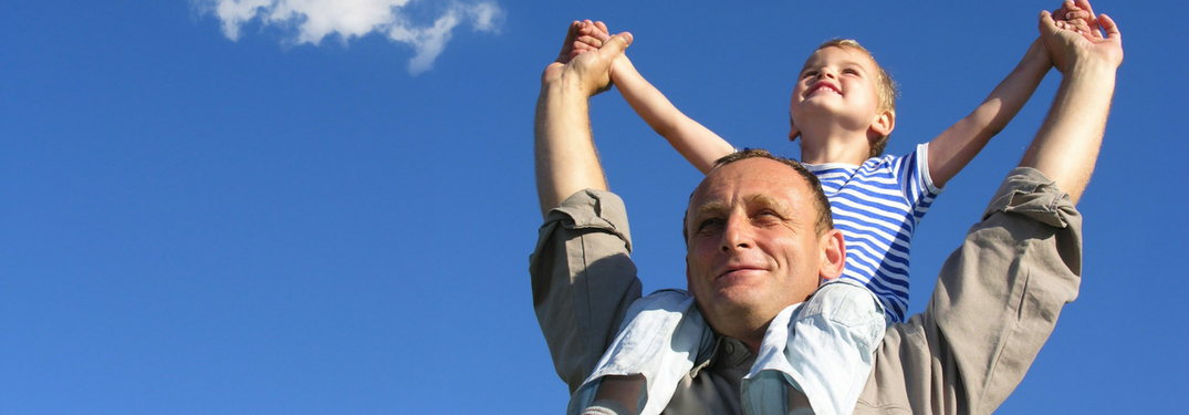little boy on dads shoulders outside