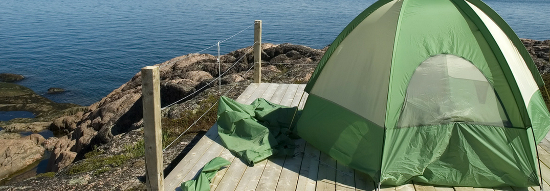 camping tent set up in front of water