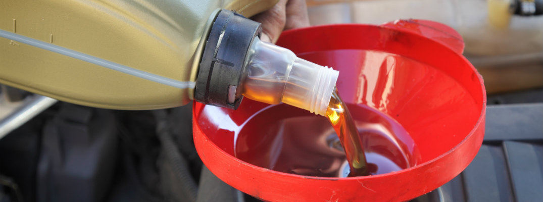 Person pouring oil into an engine