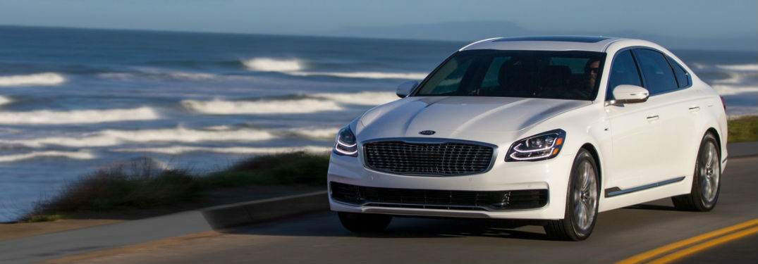 2019 Kia K900 in White Coloring Driving Down Road