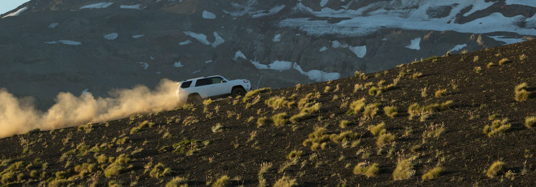 2018 Toyota 4Runner in white driving up a dusty mountain road