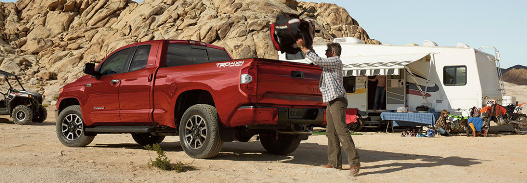 Man packing camping supplies into the back of the 2018 Toyota Tundra