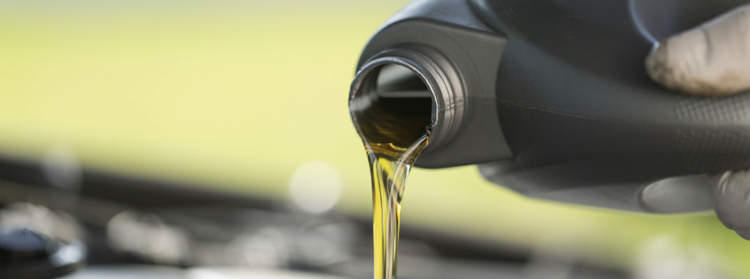 A stock photo of engine oil being poured into an engine.