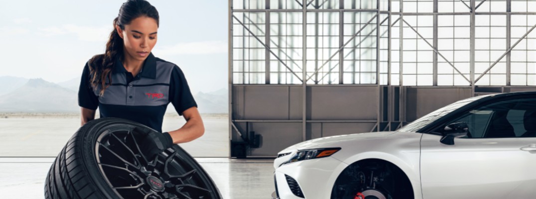 Woman holding Toyota TRD branded wheel