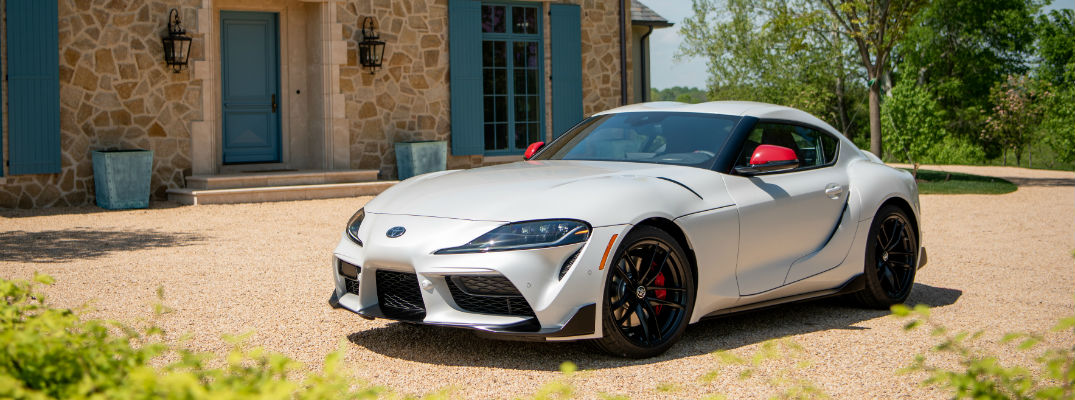 A front left quarter photo of the 2020 Toyota GR Supra parked in front a home.