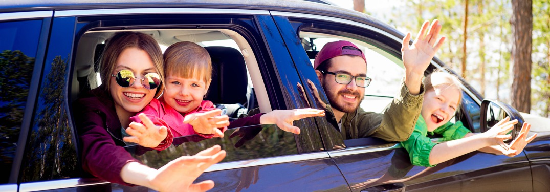 family sticking out of car windows