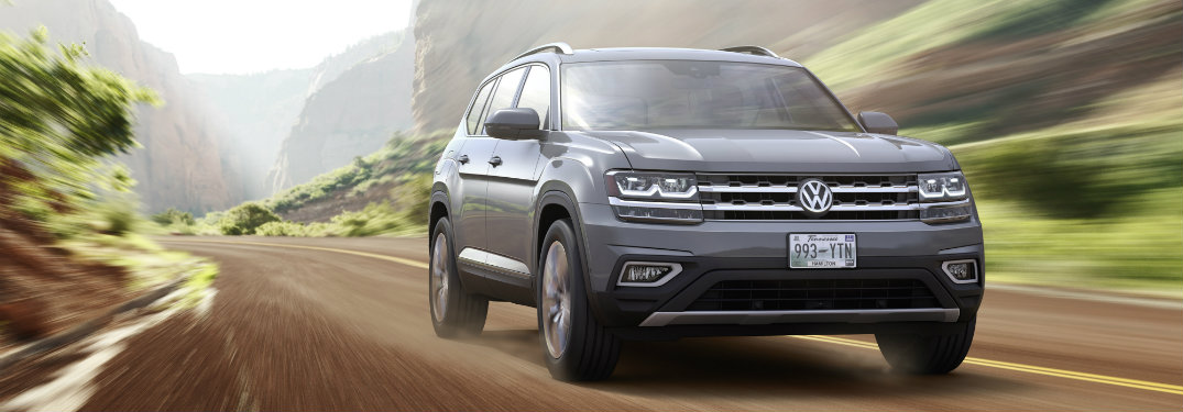 gray volkswagen atlas on dirt road by hills
