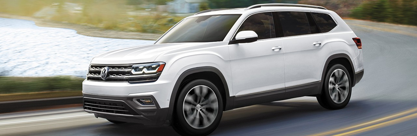 A white 2020 Volkswagen Atlas driving down an open road.
