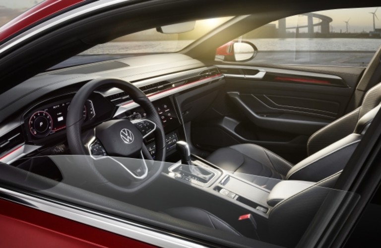 The front seating area inside a red 2021 Volkswagen Arteon.