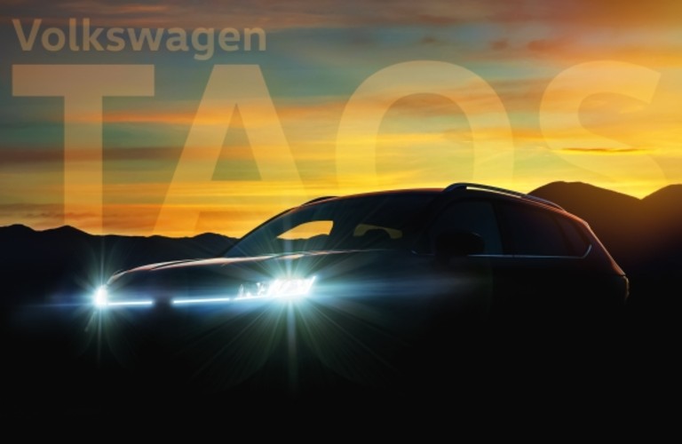 A shadowed image of the 2021 Volkswagen Taos with the caption "Volkswagen Taos" in the background.