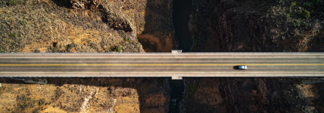 A top-down image of a bridge with a 2021 Volkswagen Taos driving on it.