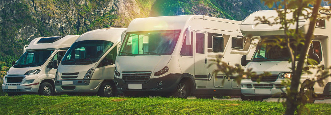 Four RVs Parked in Front of a Mountain